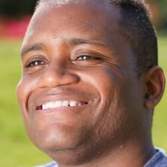 Portrait carré d'un homme souriant en extérieur, lumière naturelle