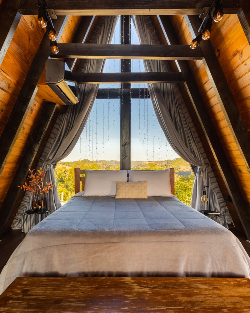 Mezzanine avec lit double et grande baie vitrée sur la canopée