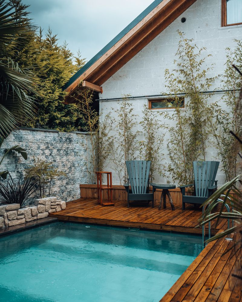 Piscine avec terrasse en bois et chaises longues