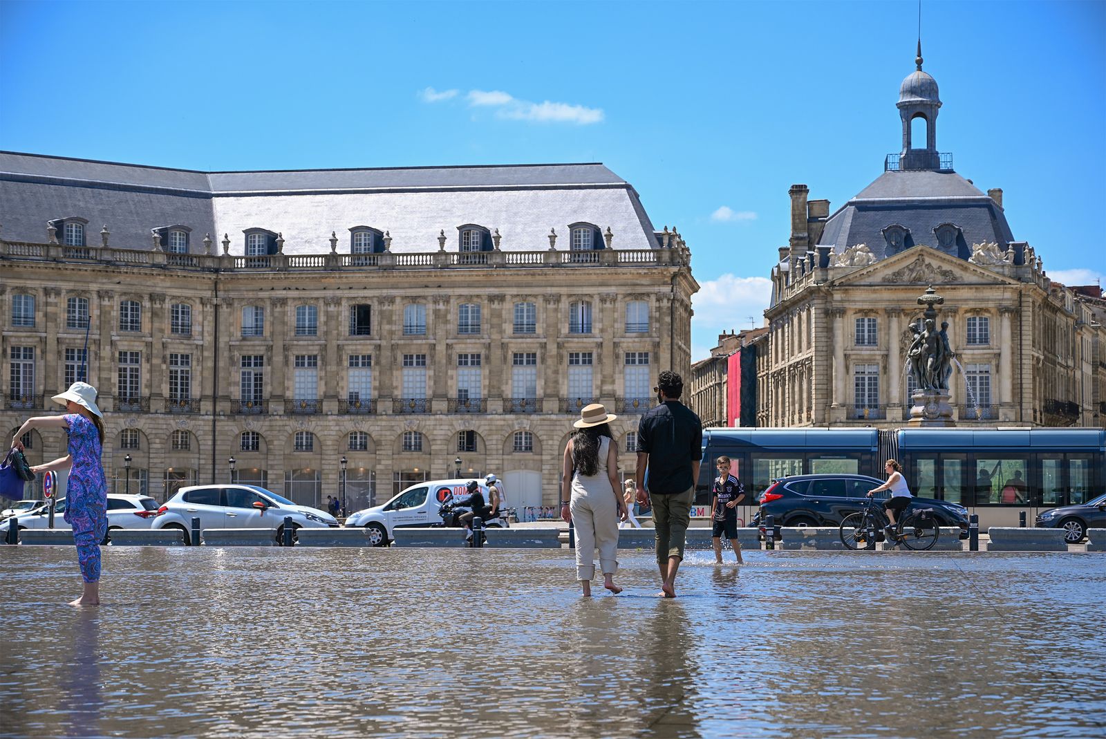 Promeneurs sur le miroir d’eau devant la place de la Bourse