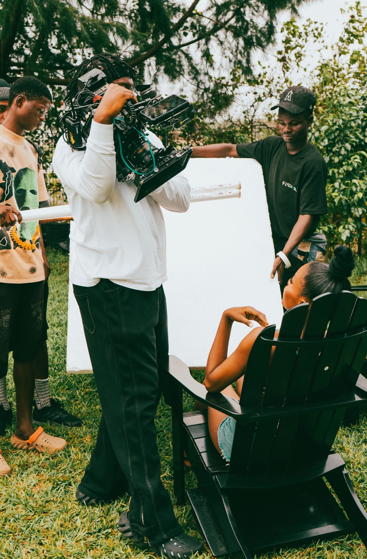 Équipe de tournage en extérieur, caméra à l’épaule et réflecteur