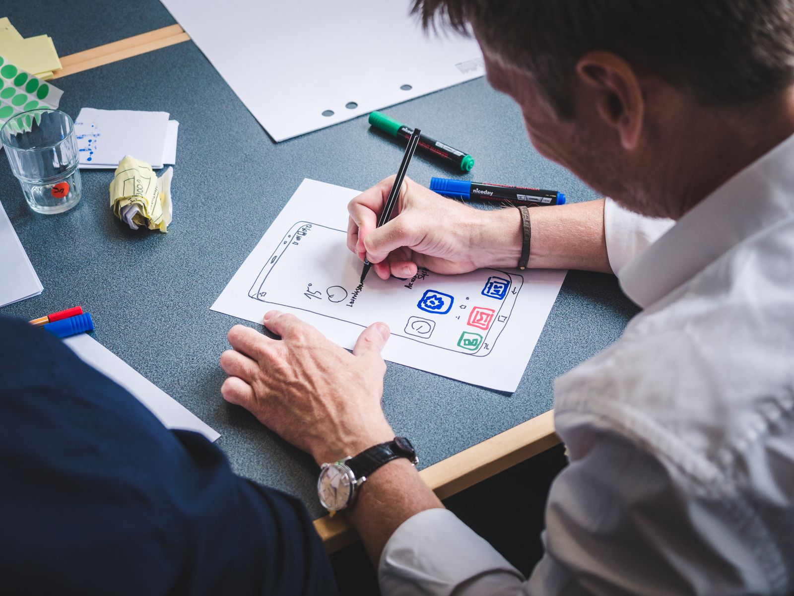 Personne dessinant une interface au feutre pendant un atelier