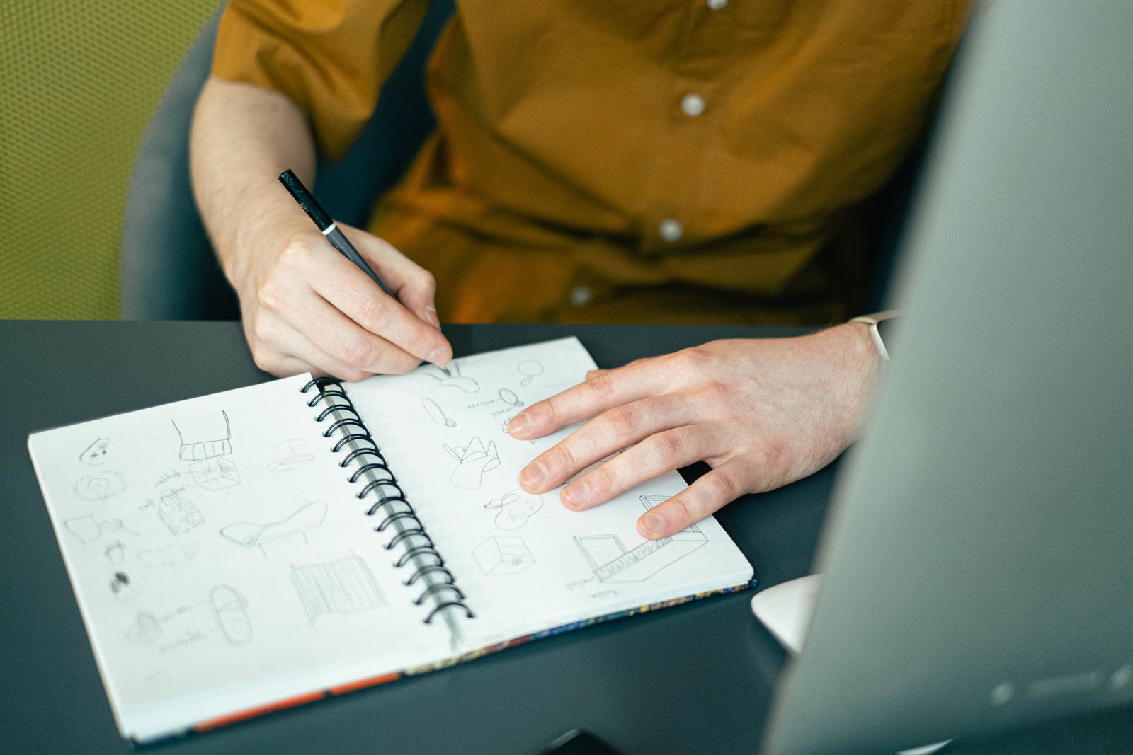 Designer dessinant des recherches dans un carnet à spirale
