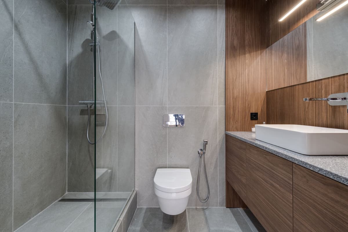 Salle de bain moderne gris et bois avec douche à l'italienne, WC suspendu et vasque à poser